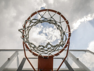 Basketball hoop against clouded sky - JMF00419