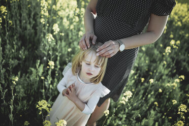 Portrait of little girl standing with her mother in rape field - PSIF00020