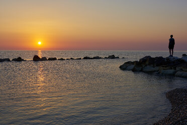 Italien, Abruzzen, San Vito Chietino, Trabocchi-Küste, Mann schaut bei Sonnenaufgang in die Ferne - LOMF00740