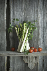 Bündel von grünem und weißem Spargel, Tomate, Petersilie und gemischtem Pfeffer auf Holz - ASF06203