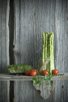 Bündel aus grünem Spargel, Tomate, Kresse, Petersilie und gemischtem Pfeffer auf Holz - ASF06204