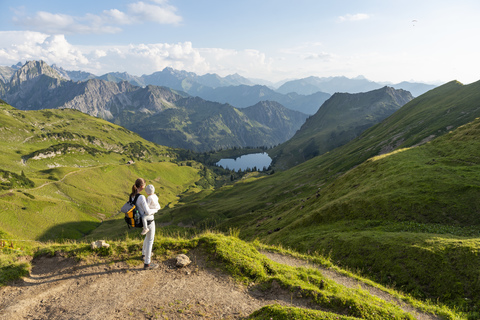 Deutschland, Bayern, Oberstdorf, Mutter und kleine Tochter bei einer Wanderung in den Bergen mit Blick auf die Aussicht, lizenzfreies Stockfoto