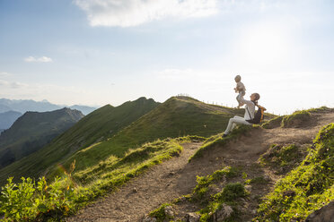 Deutschland, Bayern, Oberstdorf, Mutter und kleine Tochter auf einer Wanderung in den Bergen, die eine Pause machen - DIGF04976