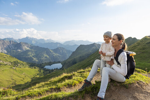 Deutschland, Bayern, Oberstdorf, Mutter und kleine Tochter auf einer Wanderung in den Bergen, die eine Pause machen - DIGF04979