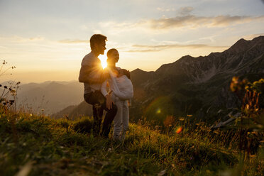 Germany, Bavaria, Oberstdorf, family with little daughter on a hike in the mountains at sunset - DIGF04991