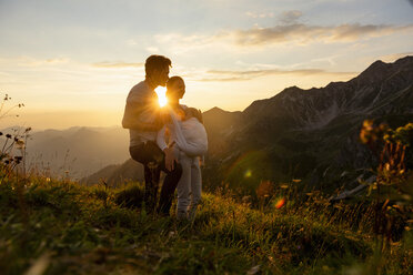 Germany, Bavaria, Oberstdorf, family with little daughter on a hike in the mountains at sunset - DIGF04992