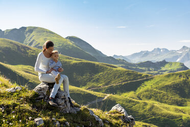 Deutschland, Bayern, Oberstdorf, Mutter und kleine Tochter auf einer Wanderung in den Bergen, die eine Pause machen - DIGF05000