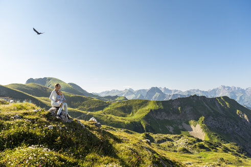 Germany, Bavaria, Oberstdorf, mother and little daughter on a hike in the mountains having a break looking at view - DIGF05001