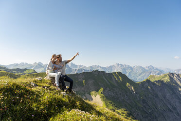 Deutschland, Bayern, Oberstdorf, Familie mit kleiner Tochter auf einer Wanderung in den Bergen, die eine Pause mit Blick auf die Aussicht macht - DIGF05002
