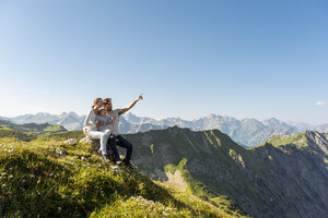 Germany, Bavaria, Oberstdorf, family with little daughter on a hike in the mountains having a break looking at view - DIGF05002