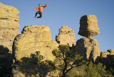 Man jumps on rock near Balanced Rock. - AURF01427