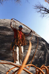 Ein Bergsteiger wickelt ein Seil auf. - AURF01492