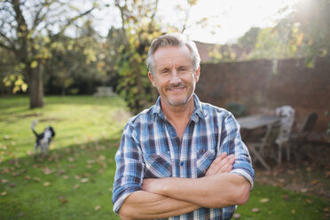 Portrait confident senior man in sunny autumn backyard - HOXF03705