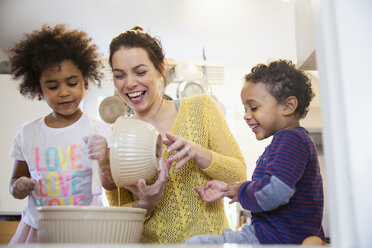 Verspielte Mutter und Kinder beim Backen in der Küche - HOXF03733