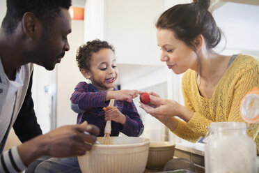 Eltern und neugieriges Kleinkind backen in der Küche - HOXF03768