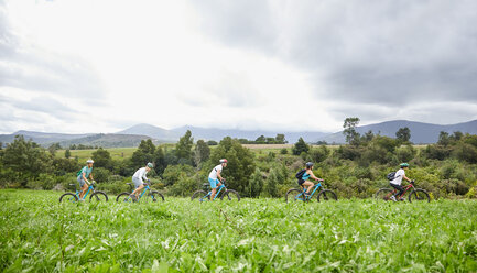 Freunde beim Mountainbiken in einem idyllischen, abgelegenen Gebiet - CAIF21329