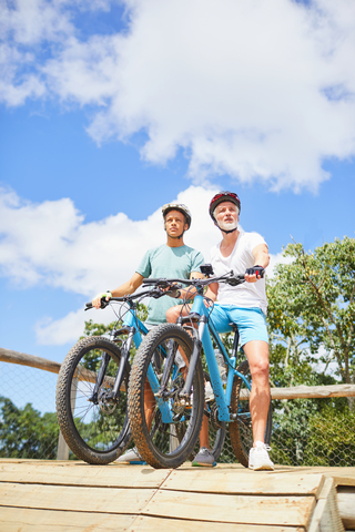 Vater und Sohn beim Mountainbiking im Hindernisparcours, lizenzfreies Stockfoto