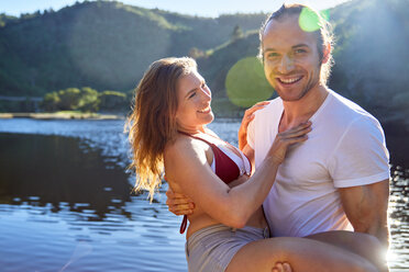 Portrait romantic, carefree couple at sunny summer lake - CAIF21379