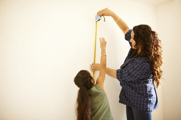 Mutter und Tochter messen die Wand für ein Projekt aus - CAIF21398