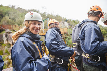 Portrait smiling woman preparing to zip line - CAIF21402