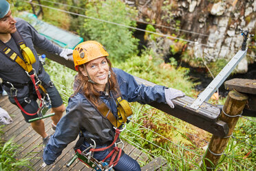 Portrait smiling woman preparing to zip line - CAIF21403