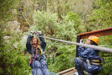 Woman zip lining above trees - CAIF21445