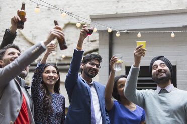 Freunde stoßen auf einer Party im Innenhof an - CAIF21467