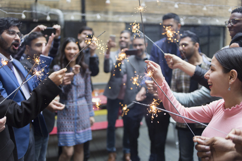 Freunde feiern auf einer Party mit Wunderkerzen, lizenzfreies Stockfoto