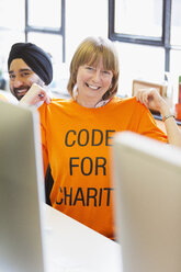 Porträt eines selbstbewussten Hackers mit T-Shirt, der bei einem Hackathon für wohltätige Zwecke programmiert - CAIF21496