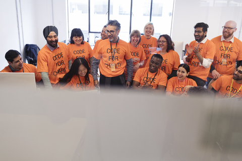 Hackers coding for charity at hackathon stock photo