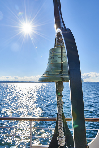 Dampfschiff Hohentwiel, goldene Handglocke, Bodensee in der Sonne, lizenzfreies Stockfoto