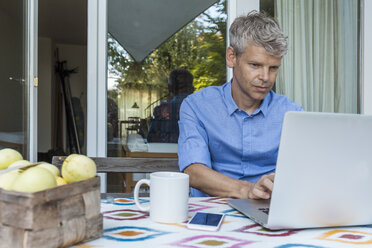 Portrait of mature man using laptop on terrace - TCF05641