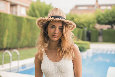 Porträt einer jungen Frau mit Strohhut und Badeanzug, Pool im Hintergrund - ACPF00266