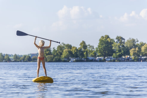 Junges Mädchen hält Paddel beim Stand Up Paddle Surfing - TCF05661