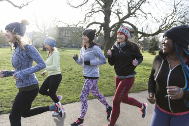 Female runners running in sunny park - CAIF21582