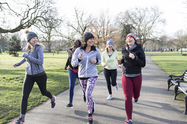 Smiling female runners running in sunny park - CAIF21586