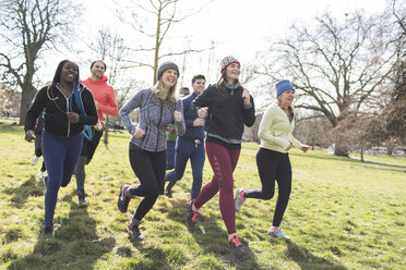 Lächelnde Läuferinnen laufen im sonnigen Park - CAIF21595