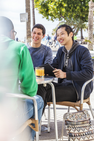 Männliche Freunde im Straßencafé, lizenzfreies Stockfoto