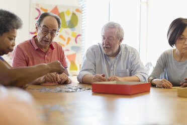 Ältere Freunde spielen Spiele am Tisch im Gemeindezentrum - CAIF21651