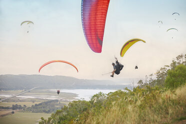 Gleitschirmflieger am Himmel über der Landschaft - CAIF21697