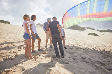 Gleitschirmflieger mit Fallschirm am sonnigen Strand - CAIF21711