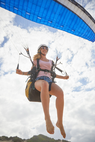 Lächelnde Gleitschirmfliegerin in der Luft, lizenzfreies Stockfoto