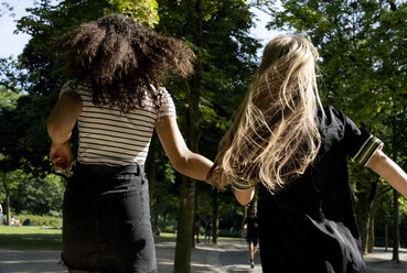 Two girlfriends running in a park, rear view - HHLMF00314