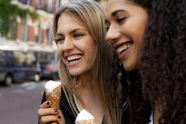 Two laughing girlfriends having fun, eating ice cream - HHLMF00347