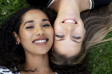 Two girlfriends relaxing in a park, lying on grass - HHLMF00357