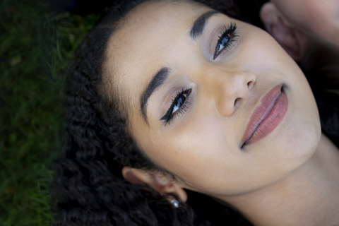 Porträt einer schönen Frau im Gras liegend, lizenzfreies Stockfoto