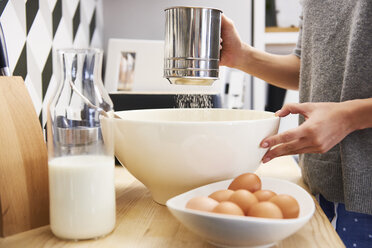 Young woman preparing batter for pancakes - ABIF00924