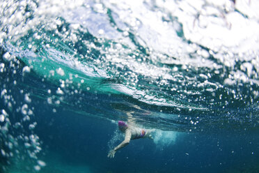 Unterwasseransicht eines Schwimmers, der ein entspannendes Bad in den tropischen Gewässern vor den Yasawas-Inseln, Fidschi, genießt. - AURF01517