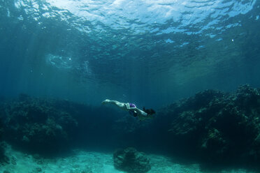 Unterwasseransicht eines Schwimmers, der ein entspannendes Bad in den tropischen Gewässern vor den Yasawas-Inseln, Fidschi, genießt. - AURF01518
