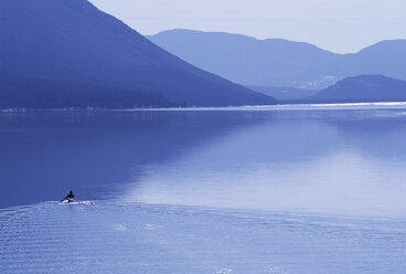 Männliche Person paddelt alleine in einem Kajak auf dem Lake McDonald, Glacier National Park, MT. - AURF01561